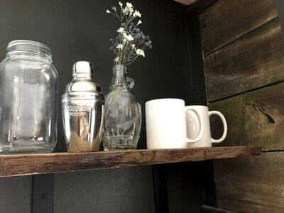 kitchen shelf with coffee mugs and a glass vase
