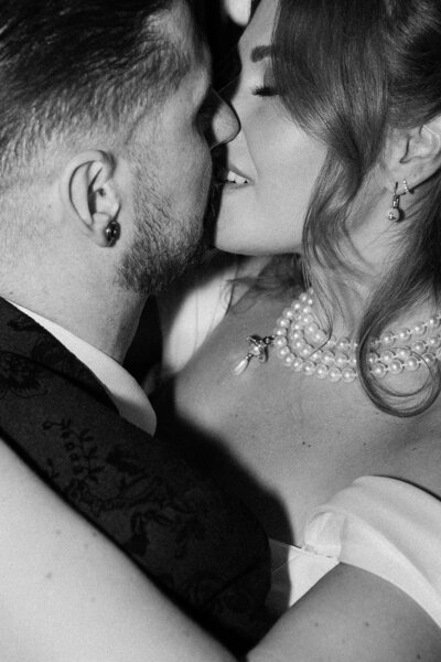 Close-up black and white portrait of bride and groom sharing a kiss, full of romantic tension and editorial (the river barn blackpool) wedding intimacy.