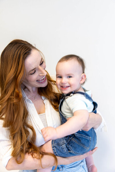 Mom smiling while holding her toddler