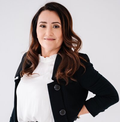 A professional photo of Danielle standing in a suit