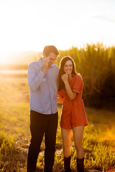 Engagement couple laughs under the sun
