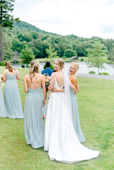 Bride walks across field with her bridesmaids