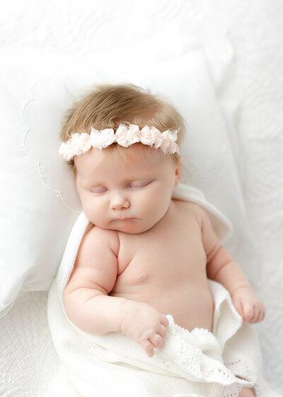 newborn baby girl sleeping on a white pillow with Constance Calton photography in Savannah, Ga