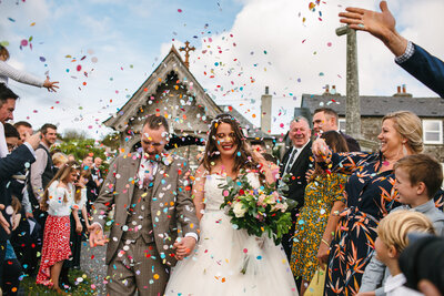Couple just married at church wedding on Dartmoor get showered in colourful confetti 