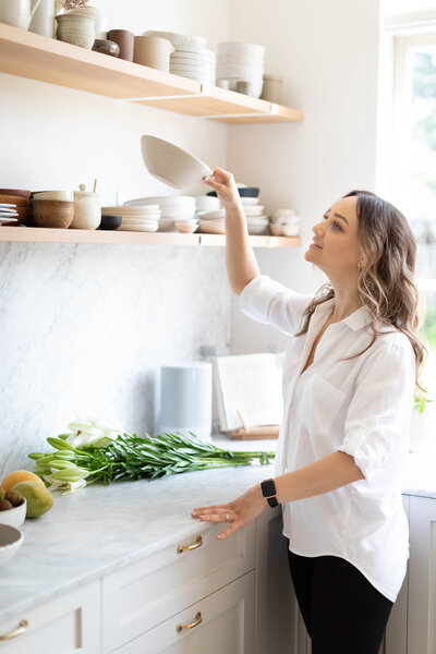 Interior designer Taleah Smith styling open shelves in a kitchen