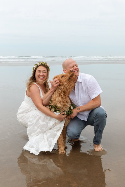 Just married couple poses with their dog in Canon Beach right after their intimate wedding.