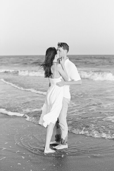 couple sharing a kiss in the ocean in charleston