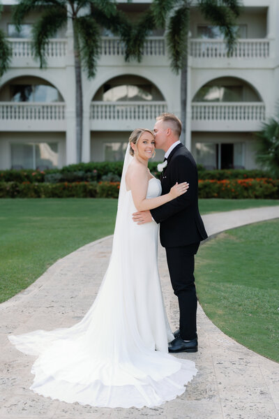 Black and white flash image of bride and groom kissing in wedding reception outfits at Cape May wedding
