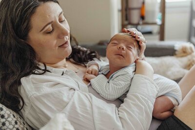 Baby scrunching on mom's chest during newborn photography session in Chicago, IL