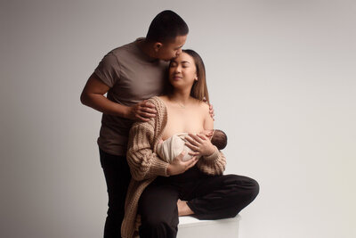 mother and daughter family motherhood portrait sitting on a chair with Couture gown in studio