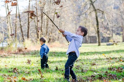Boys playing in fall leaves