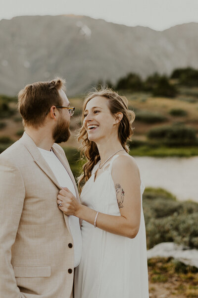 Couple holding each-other near a lake during their Colorado elopement.