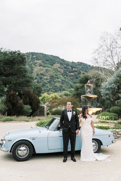 Bride and groom with light blue classic car at Gardener Ranch