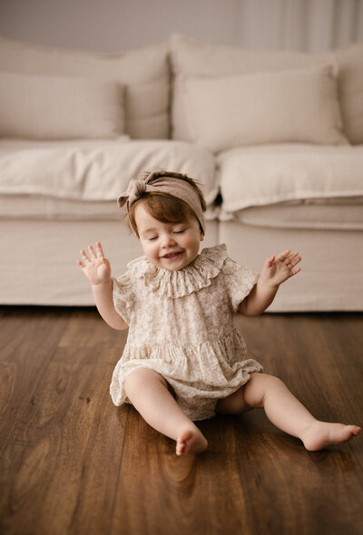 Little toddler macie waving to the camera during her milestone photography shoot in new plymouth