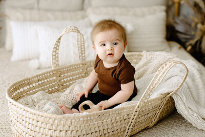 Family photography child sitting in basket on white blanket with boho background in Tampa Bay, Florida Nadine B Photography