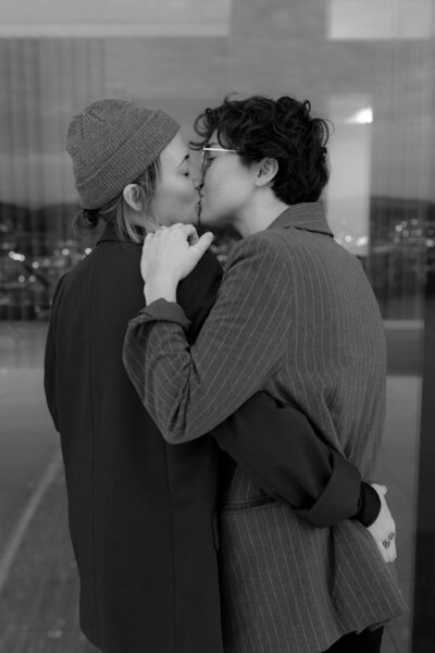 Two brides kiss during photographs prior to their intimate wedding at City Hall in Portland, Oregon.