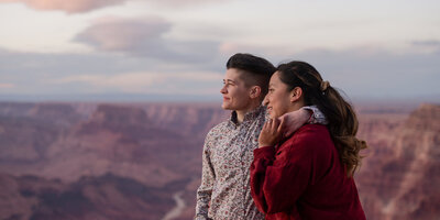 Two women embracing joyfully after one proposes to the other at the Grand Canyon, surrounded by the incredible natural beauty of the canyon