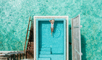 Woman swimming on the pool that's connected to the ocean