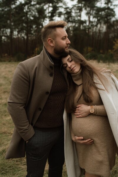 Zwangere mama op de foto samen met haar vriend tijdens een koppelshoot in de natuur.