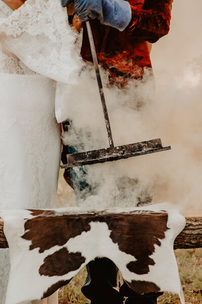 branding cowhide at ranch wedding ceremony