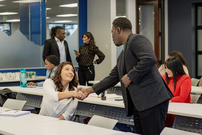 Chad Nash Ph.D. shaking the hand of a student in his class that is learning about how to build wealth