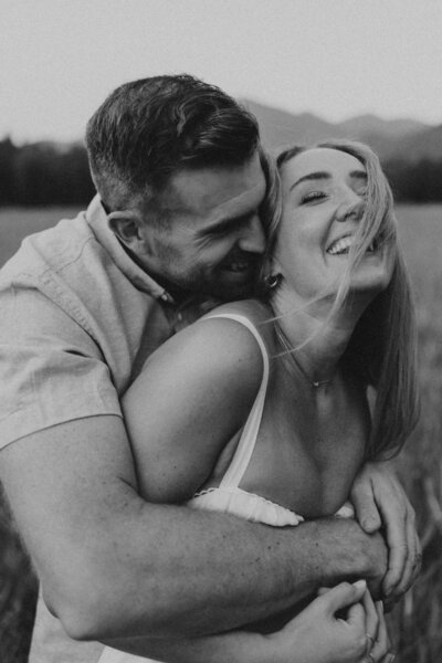 couple holding onto each other during couples photos in glacier national park 