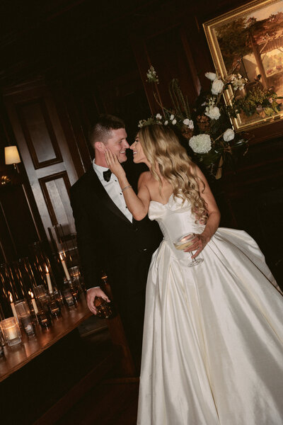 Moody wedding photos showcase bride and groom embracing surrounded by candles.