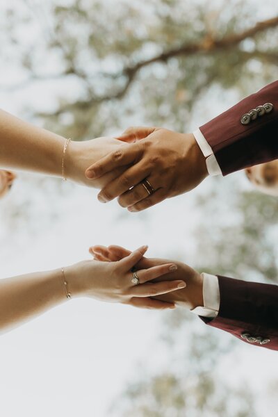 bride and groom holding hands showing wedding rings
