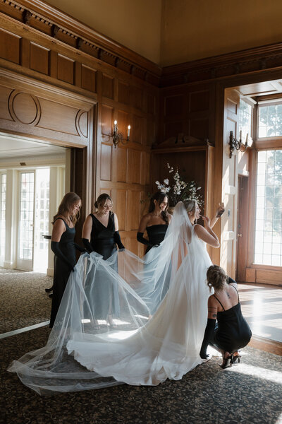 candid bride and bridesmaid getting ready photo at estate 