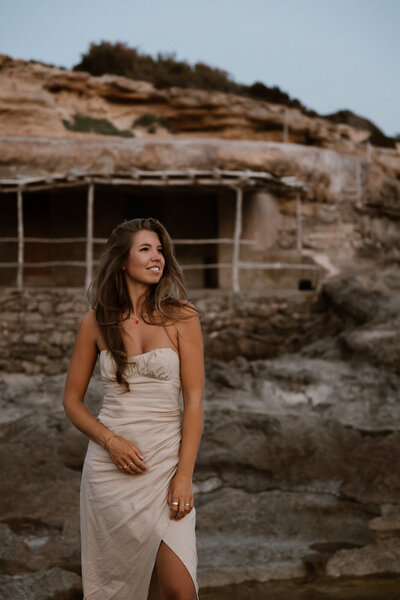 Woman is posing in front of a fisherman's cabin on Ibiza for a shoot
