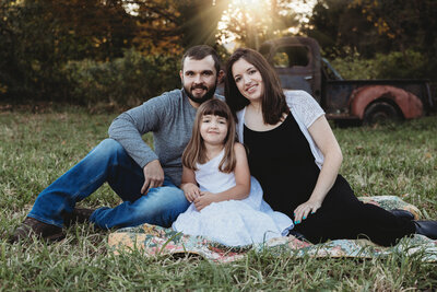 A family sitting in a field.