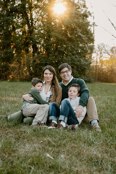 Family photo taken with mom, dad, and two young sons wearing green , white and tan in Annapolis Maryland