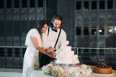 Couple cutting wedding cake at N Ervay wedding venue