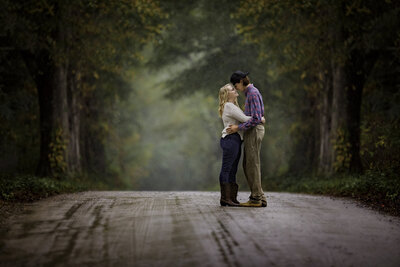 Engaged couple standing in the rain with a whimsical, dreamy background, gazing into each other's eyes in a beautifully romantic moment.