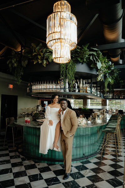 couple sits at bar and enjoys a cocktail during thier engagement photos