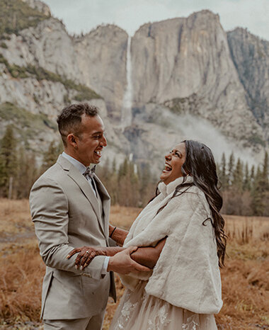 Bride and Groom embrace with lake in background