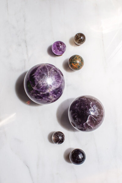 A bird's eye view of some stunning crystal spheres over a white marble surface.