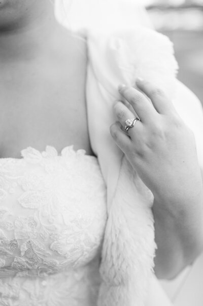 A B&W Photograph of an engagement ring on bride's hand.