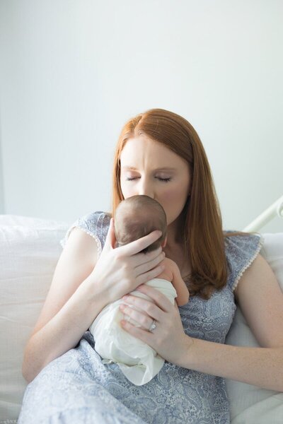 Mother cradling newborn during photography session in Savannah, Georgia