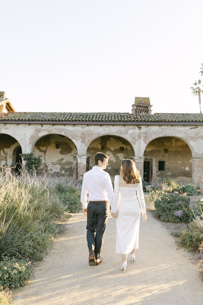 Engaged couple walking through Arizona garden for engagement photos