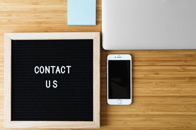 contact-us-sign-with-phone-on-desk