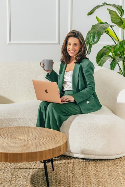 Julia Korn Green Suit Sitting on Couch