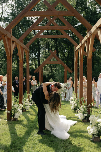 Bride laughing while walking down the aisle with mom and dad