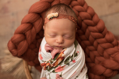 Baby girl wrapped in fall floral wrap with matching headband