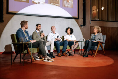 a group of professional panelists at a corporate speaking event
