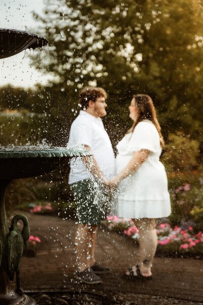 A newly engaged couple near a fountain at Pineland Farms Gardens in New Gloucester, Maine