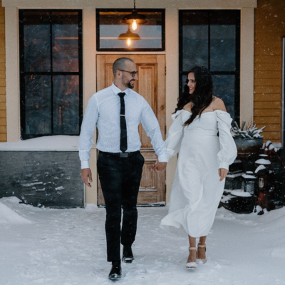 Man and women walk holding hands in snow
