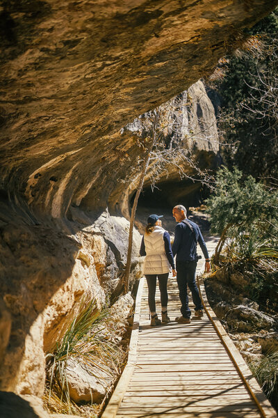 Man and woman hiking next to large rocks