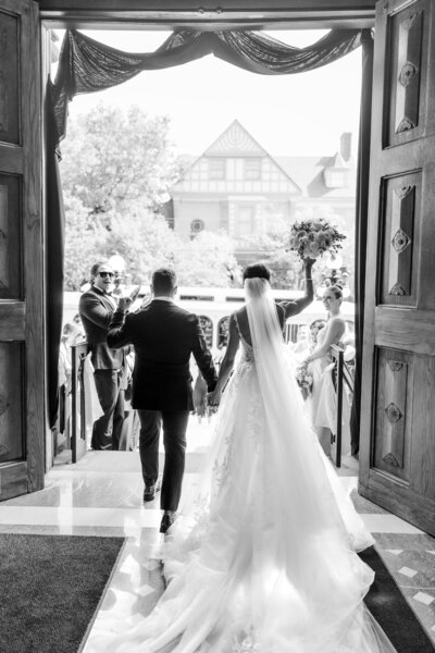 bride and groom leaving church as guests celebrate