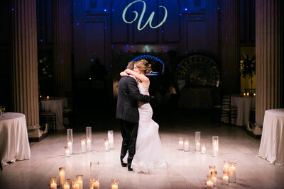 Bride and groom having their first dance surrounded by candles